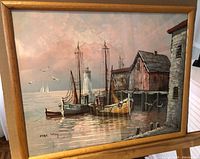 Full view of signed framed harbour scene oil painting showing boats, lighthouse, pier building and wood frame