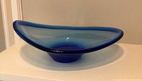 Angled view of blue freeform art glass bowl