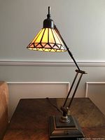 Full view of Tiffany-style swing-arm desk lamp on table