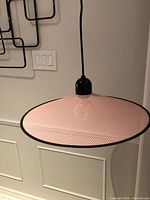 Overall view of pink perforated pendant lamp hanging