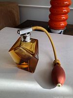 Overall view of faceted amber glass perfume bottle with atomizer bulb