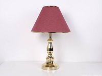 Full view of brass lamp with red shade, lamp off