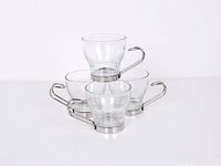 Stacked view of all four clear glass cups showing chrome handles and bases