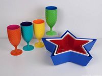 Overall lot: four colorful plastic stem goblets and three star-shaped nesting bowls