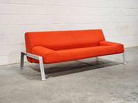 Front angled view of red IKEA Erska sleeper sofa showing upholstery and aluminum legs