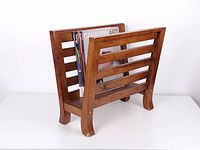 Angled view showing oak slatted magazine holder with magazines for scale