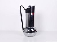 Front view of chrome Studio Nova thermos showing black handle and dome lid