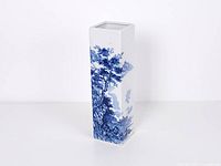 Front view showing blue landscape painting on white square vase