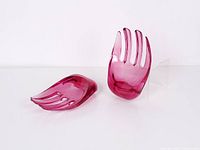 Two translucent purple lucite salad hands, one resting on side, one upright