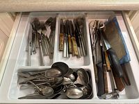Drawer organiser holding forks, spoons, knives, kitchen tools
