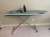 Iron resting on fully extended ironing board