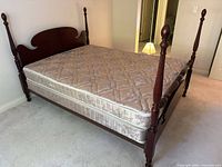 Four-poster mahogany bed with mattress and box spring side view
