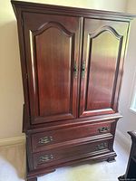 Front view of closed dresser showing paneled doors and lower drawers