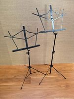 Both black folding music stands fully opened and standing