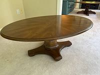 Full view of oval wood coffee table top and base