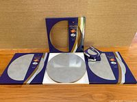 All packaging showing three boxes of placemats and two boxes of coasters, one placemat displayed