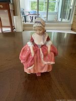 Front view of Royal Doulton Goody Two Shoes figurine standing on table.