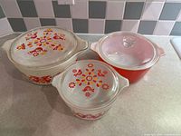 Three round casseroles with lids showing Friendship pattern and solid red dish