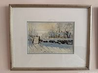 First framed print showing snowy field, fence and trees