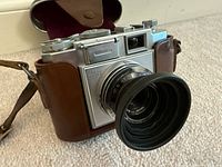 Front view of camera in leather case showing Tessar 45mm f/3.5 lens with hood