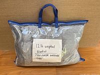 Weighted blanket in clear storage bag with carry handles and handwritten label