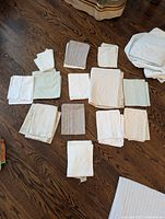 Assorted folded sheets and pillowcases laid out on hardwood floor