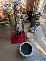 Group shot of assorted planters, vases, containers on floor