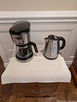Coffee maker and kettle front view on table