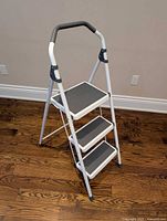 Front view of 3-step ladder showing steps and handle