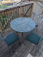 round metal lattice-top table and four chairs on deck