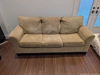 Front view of light brown three-cushion sofa