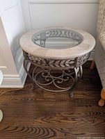 Full view of round side table between walls and chair