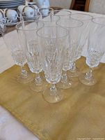 Front angled view of 10 crystal cut champagne flutes grouped together