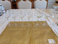 Seven clear wine glasses lined up on table
