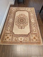 Full view of ornate wool area rug on wood floor