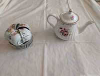 Overall view showing teapot, stacked cups and saucers