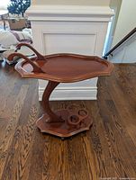 Full view of wooden bar cart showing tray, curved support and base on casters