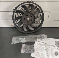Front view of 10" slim electric radiator fan with mounting hardware bags