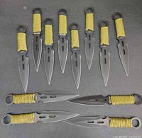 Twelve knives laid out showing full blade and handle design