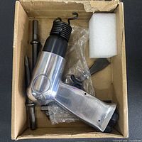Air hammer with chisels and spring retainer inside box