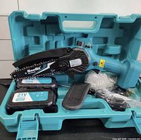 Chainsaw with accessories in open teal carry case