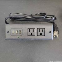 Front view showing 3 USB-A ports, LED, and 2 AC outlets