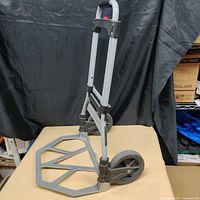 Hand truck standing with handle extended and platform unfolded