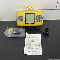 Timer with accessories and manual on table