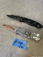 Black and silver folding knives on tabletop
