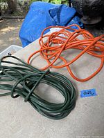 Orange and green extension cords coiled on tabletop