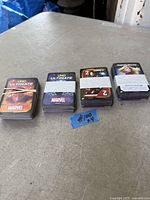 Four Marvel UNO Ultimate decks side by side on table, paper bands visible