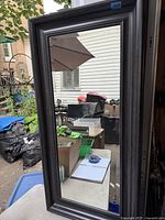 Front view of rectangular beveled wall mirror in wood frame