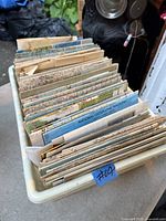 Plastic bin filled with numerous folded maps showing variety and quantity