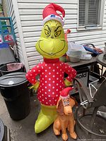 Full view of Grinch plug-in inflatable with attached dog